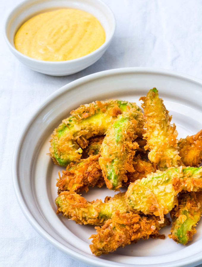 Knusprige Avocado Wedges in schöner Porzellanschale mit Mango-Curry-Dip
