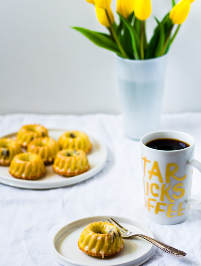Mini Eierlikör-Gugelhupfe mit einer Tasse Kaffee und gelben Tulpen