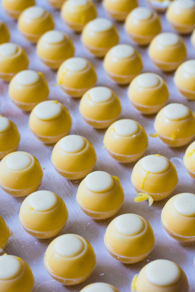 Pralinenhohlkörper mit aufgespritztem Deckel aus weißer Kuvertüre